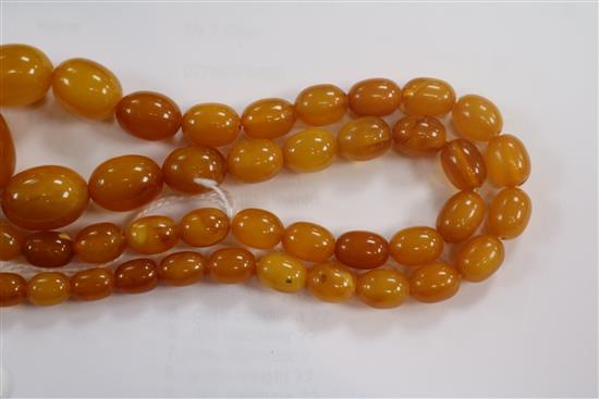 A single strand amber bead necklace, 28grms and an amber cigar holder.